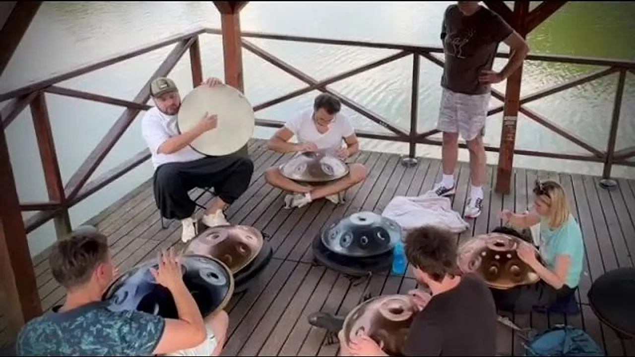 Kadr z filmu: uczestnicy 8. spotkania Handpan Łódź grają na handpanach na molo nad stawem w Zgierzu